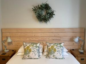 a bed with two lamps and a wreath on the wall at Beach Lodge in Bournemouth