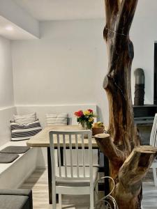 a dining room with a table and a tree at Ferienhaus Stadtmauer in Lichtenfels