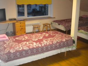 a bedroom with two beds and a dresser and two stools at Madise Guesthouse in Jõgeva