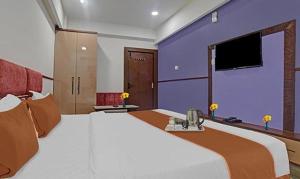 a large bedroom with a large bed and a tv at FabHotel Elite Residency in Indore