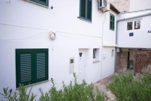 ein weißes Haus mit grünen Rollläden drauf in der Unterkunft Apartment Fly in Split