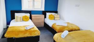 two twin beds in a room with blue walls at Browning House Bedrooms I Long or Short Stay I Special Rate Available in Derby