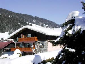 un edificio con nieve en el techo. en CHALET HOLIDAY, en Les Gets