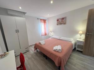 1 dormitorio con 1 cama con 2 toallas en Camere Dieci Maggio, en Ponza