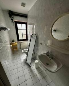 a white bathroom with a sink and a mirror at Pension Zum Erzgebirge in Kurort Altenberg
