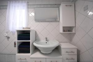 a white bathroom with a sink and a mirror at Ferienhaus Scheer in Retz +15 photos