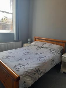 a bedroom with a bed with a white comforter and a window at Home from Home in Faversham