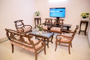 - un salon avec une table, des chaises et une télévision dans l'établissement Fortune Home Service Apartment 1bhk, D-198,UGF, à New Delhi