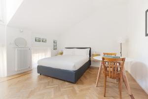 a bedroom with a bed and a desk and a chair at Spiga 46 Suites by Brera Apartments in Milan