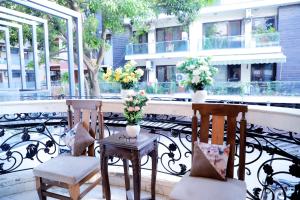 2 stoelen en een tafel met bloemen op een balkon bij Fortune Home Service Apartment 1bhk, D-198,UGF in New Delhi