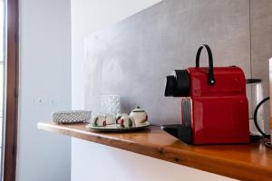 a red coffee maker sitting on a wooden counter at Fermata Cappuccini in Acireale