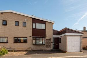 a brick house with a white garage at Bousfield Crescent in Newton Aycliffe