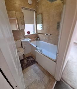 a bathroom with a tub and a toilet and a sink at Lovely home close to MCR centre inc Cinema in Manchester