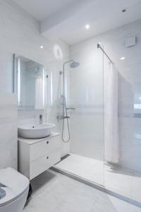 a white bathroom with a shower and a sink at Bright 2-BD Top Central Apartment in Sofia