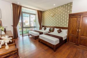 sypialnia z 2 łóżkami i dużym oknem w obiekcie Villa Bảo Anh Dalat w mieście Da Lat