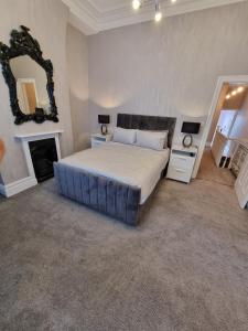 a bedroom with a large bed and a mirror at Lovely home close to MCR centre inc Cinema in Manchester