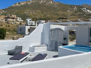 a white house with a swimming pool on a hill at Eye of Naxos in Naxos Chora