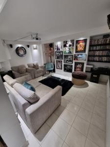 uma sala de estar com sofás e quadros na parede em Lovely home close to MCR centre inc Cinema em Manchester