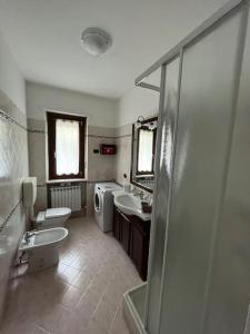 a bathroom with two sinks a toilet and a shower at La Casa Di Sabi in Locana