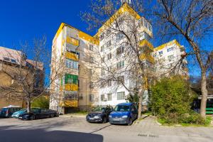 een groot gebouw met auto's geparkeerd voor het bij 1-Bedroom Flat with Balcony in Plovdiv in Plovdiv