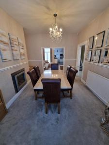 a dining room with a table and chairs and a chandelier at Lovely home close to MCR centre inc Cinema in Manchester