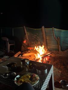 a person sitting in front of a fire at The woodswalk Treks and tours in Pahalgām