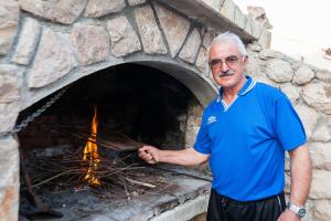 een man die voor een bakstenen oven staat bij Apartments Karlo in Vinjerac