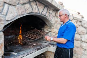een man die voor een bakstenen oven staat bij Apartments Karlo in Vinjerac