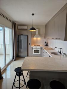 a kitchen with a refrigerator and a counter with stools at Villa Olivetum in Marina