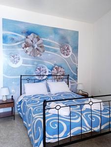 een slaapkamer met een bed met een schilderij aan de muur bij Studio Poseidon in Lipsoi