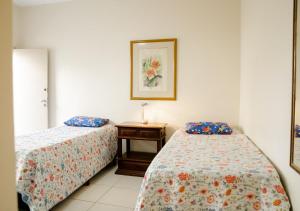 a hotel room with two beds and a table at Terreo 3qtos,6camas,3tvs in Cabo Frio