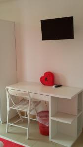 a white desk with a television on a wall at Cilento Holiday Village in Montecorice