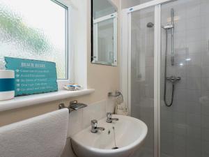 a white bathroom with a sink and a shower at Hydan Creek Gardens in Wootton Bridge