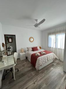 biała sypialnia z łóżkiem i biurkiem w obiekcie Casa Rural en Valera El Rincón de Elena w mieście Valera de Abajo