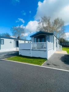 a house with a white fence in front of it at Evergreen Lodge with Hot Tub in York