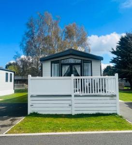 a white fence in front of a house at Evergreen Lodge with Hot Tub in York