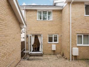 a brick house with a table and a chair at Hydan Creek Gardens in Wootton Bridge