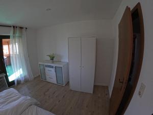 1 dormitorio con armario blanco y cama en J&J Apartment en Wutöschingen