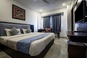 - une chambre avec un lit et une télévision à écran plat dans l'établissement Viaan - Boutique Hotel In Udaipur, à Udaipur