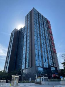 um edifício preto alto com muitas janelas em April Fair Duplex Apartment Guagnzhou South Railway Station Min Jie Branch em Guangzhou