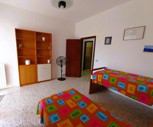 a bedroom with two beds and a fan in it at Casa Vacanze AlbA in Bari +8 photos