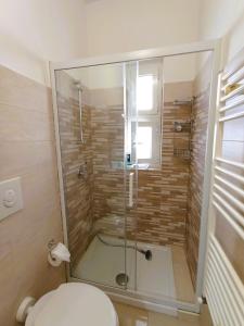 a bathroom with a glass shower with a toilet at Casa Vacanze AlbA in Bari