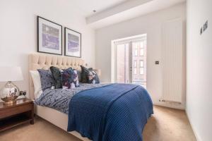 a bedroom with a bed with a blue comforter at Buckingham Palace Observatory in London