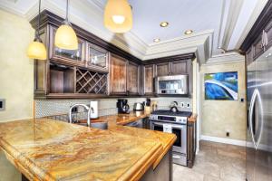 a kitchen with wooden cabinets and a marble counter top at Villa Bella Mare at the Retreat in Laguna Beach in Laguna Beach