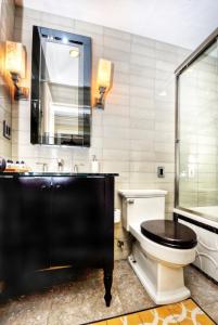 a bathroom with a toilet and a sink and a mirror at Villa Bella Mare at the Retreat in Laguna Beach in Laguna Beach