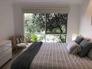 a bedroom with a large bed with a large window at 4 bedroom family holiday home with large deck in Blairgowrie