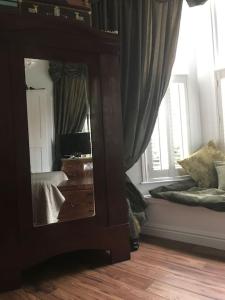 een spiegel in een kamer met een bed en een raam bij Lakeside View Arts and Craft Apartment in Liverpool