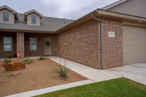 a house with a brick wall and a garage at Luxury Lubbock Home Retreat near Texas Tech in Lubbock