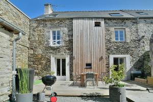 una casa de piedra con una parrilla delante en Ty Karet - Maison pour 6 proche plage, en Saint-Cast-le-Guildo