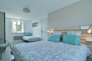 1 dormitorio con 1 cama grande y 1 silla en Ty Karet - Maison pour 6 proche plage, en Saint-Cast-le-Guildo